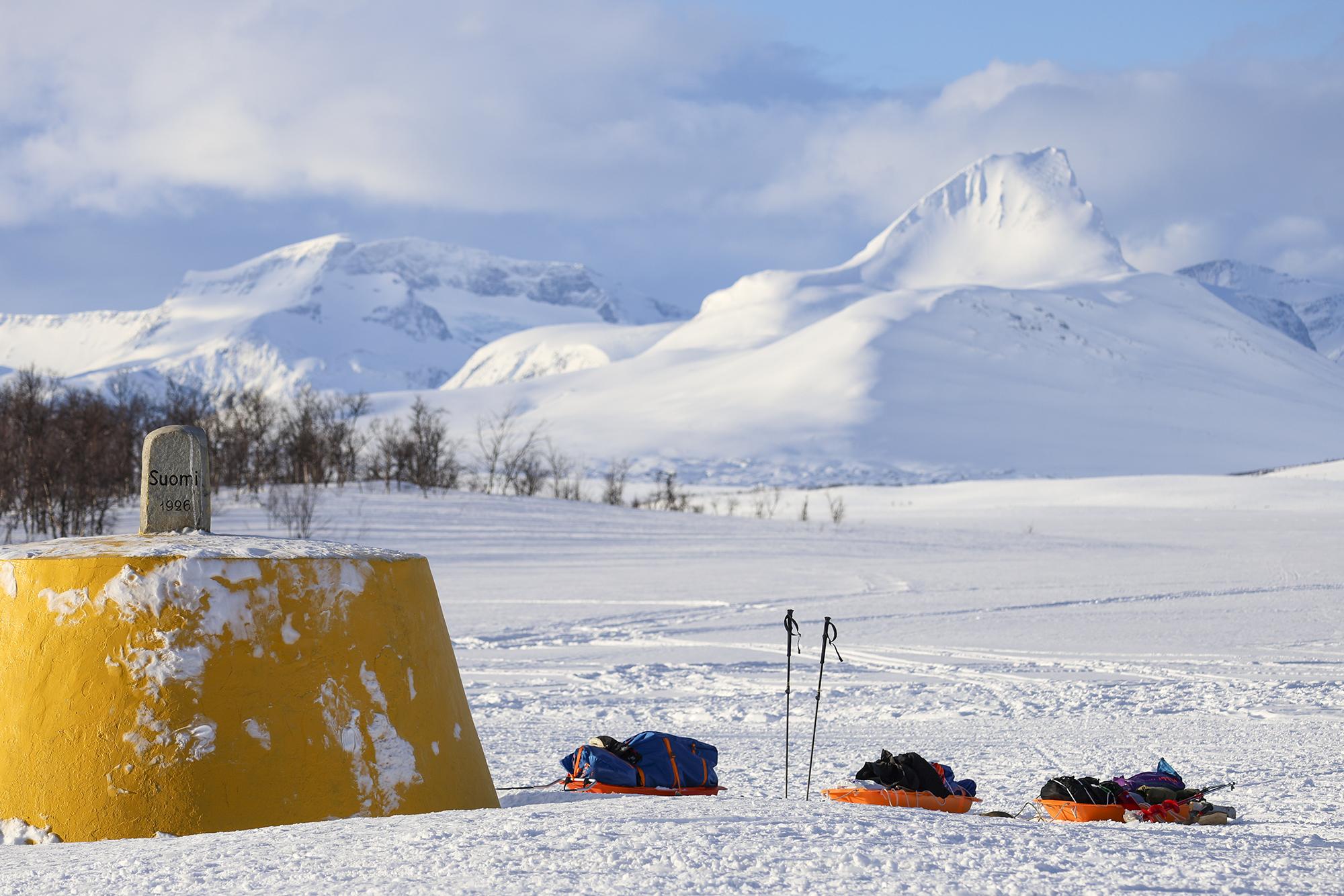 Three Nations' border point in the spring time. There are also skis and pulkas in the front