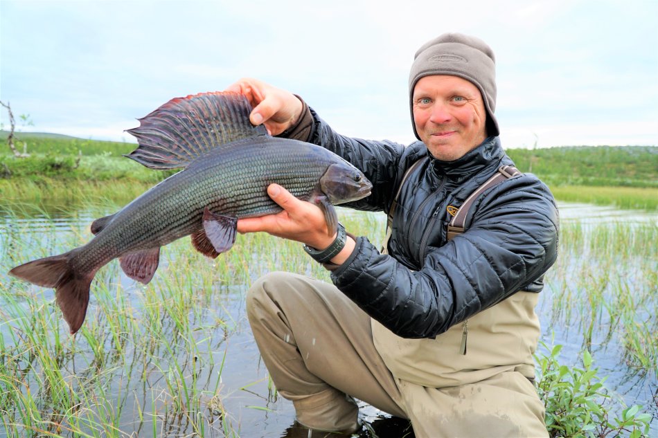 A fishing guide from Grayling Land holding a magnificent grayling in Kilpisjärvi.