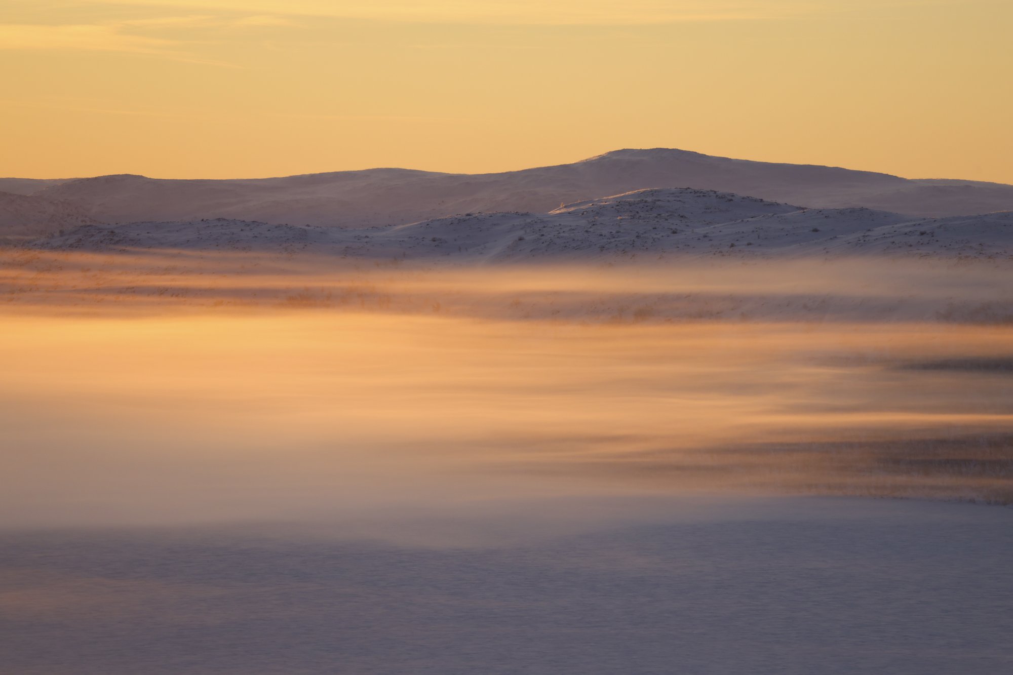 Polar night ends at Salmivaara Kilpisjärvi. The sky is burning orange.
