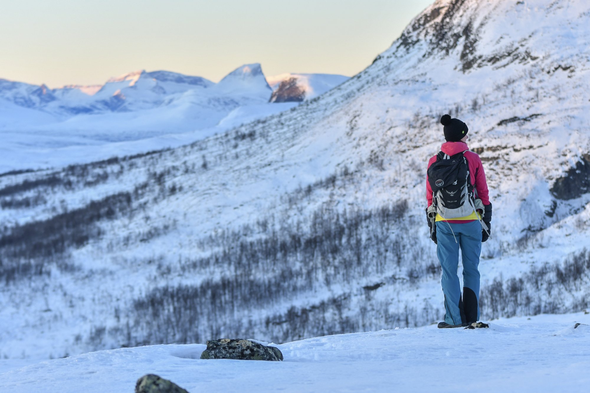 Nainen katsoo kohti barrasta Mallan luonnonpuistosta lumipeitteisenä aikana.