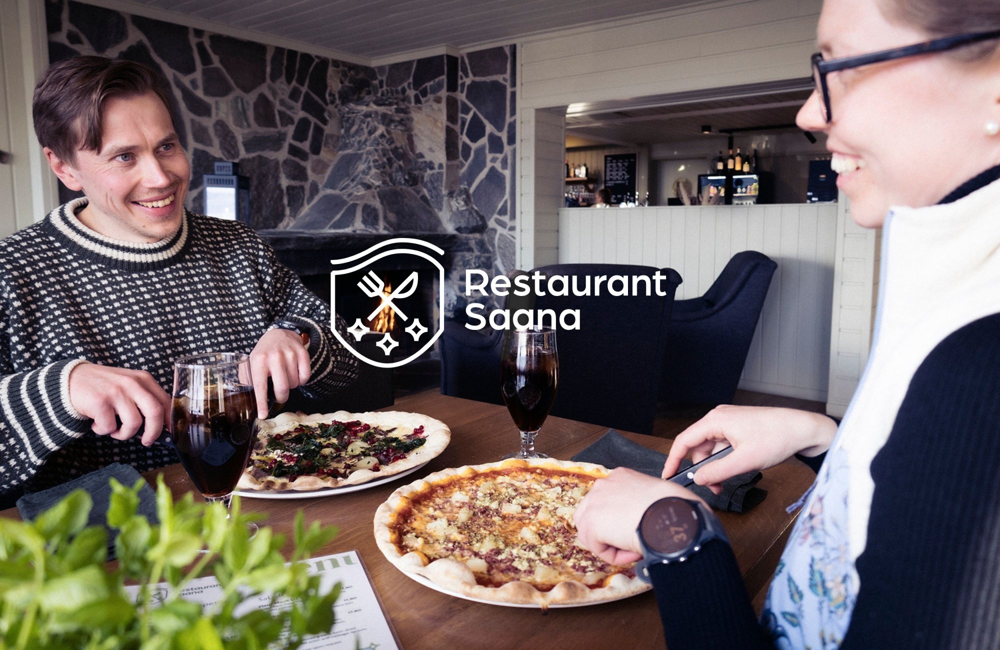 Vesa and Jenni are enjoying pizzas and smiling to each other in restaurant Saana