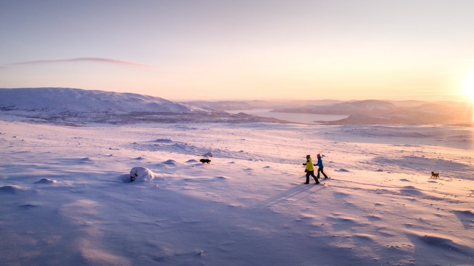 Two people skiing in sunset at mountains of Kilpisjärvi