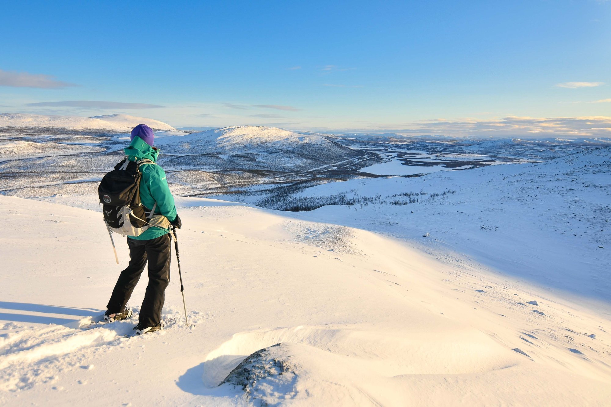 A woman is snow shoeing on a lappish fell.